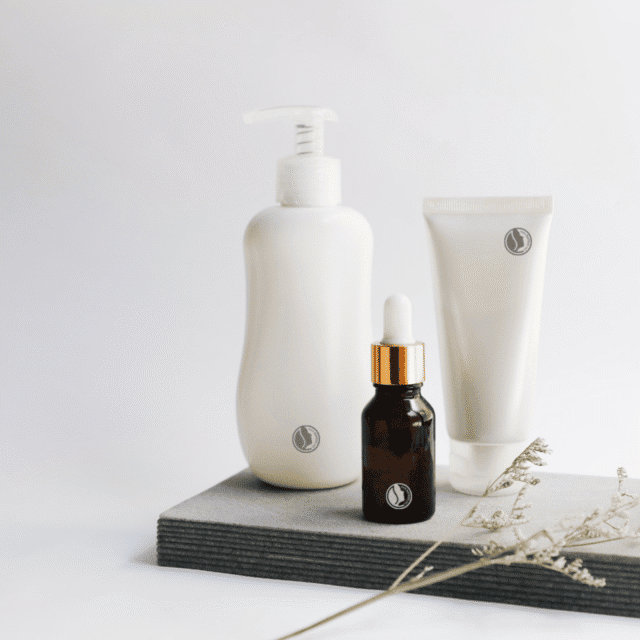 A bottle of oil, a bottle of lotion and a tube of cream.