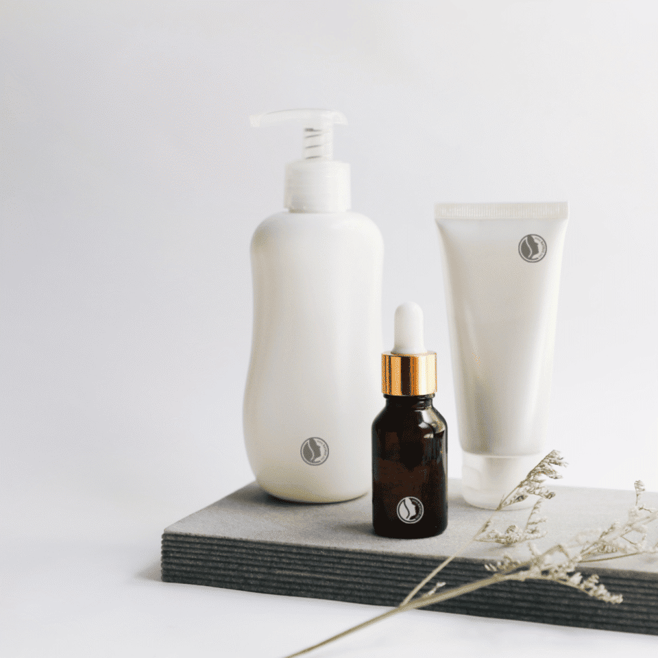 A bottle of oil, a bottle of lotion and a tube of cream.