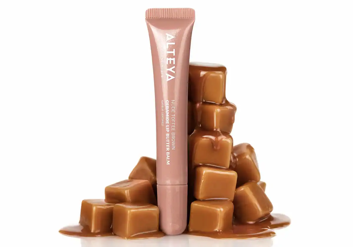 Био гланц за устни серамиди NUDE TOFFEE BROWN от Alteya Organics, поставен върху шоколадови бонбони за натурален и луксозен вид.